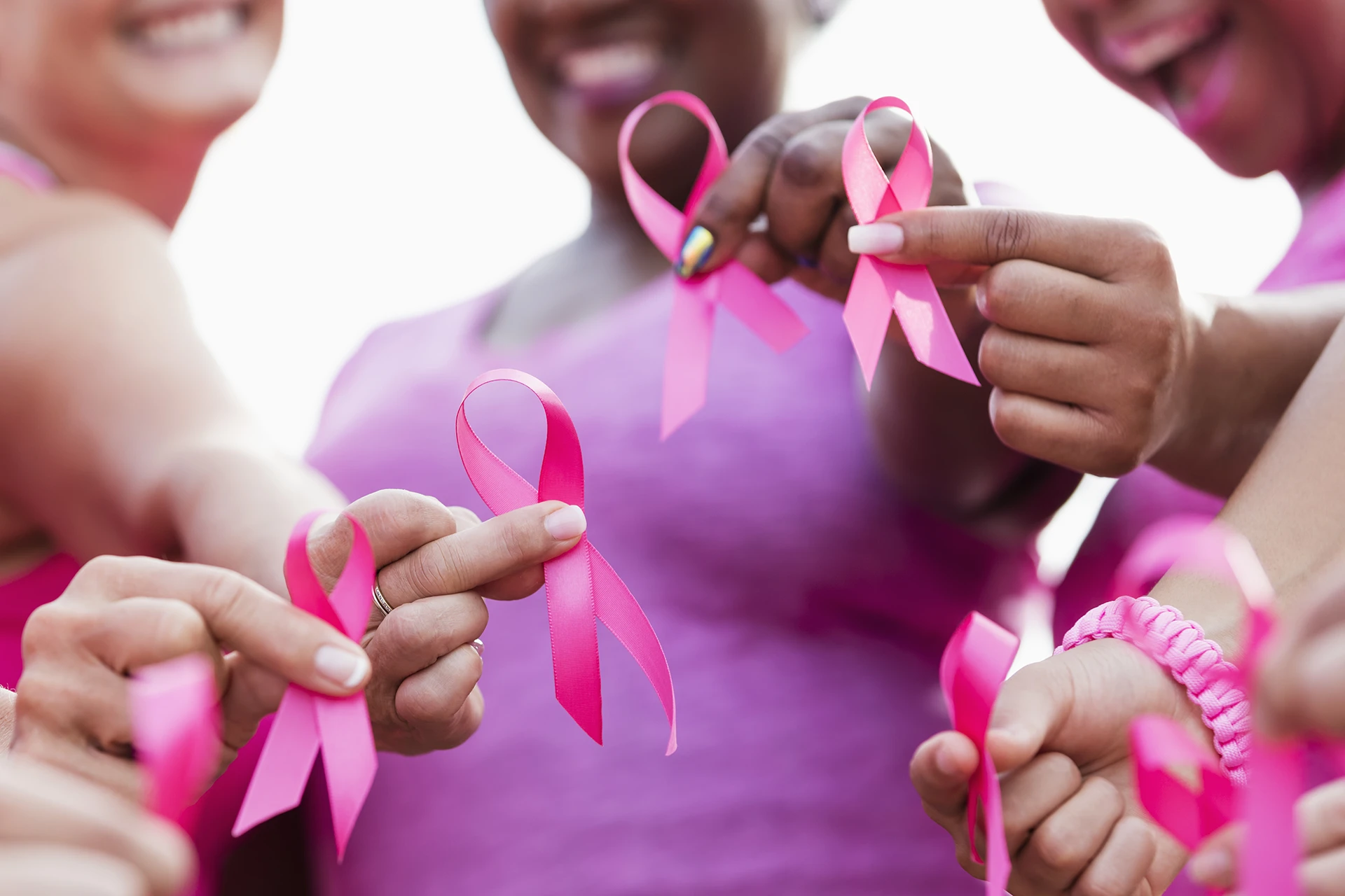 Cancer survivors holding pink ribbons