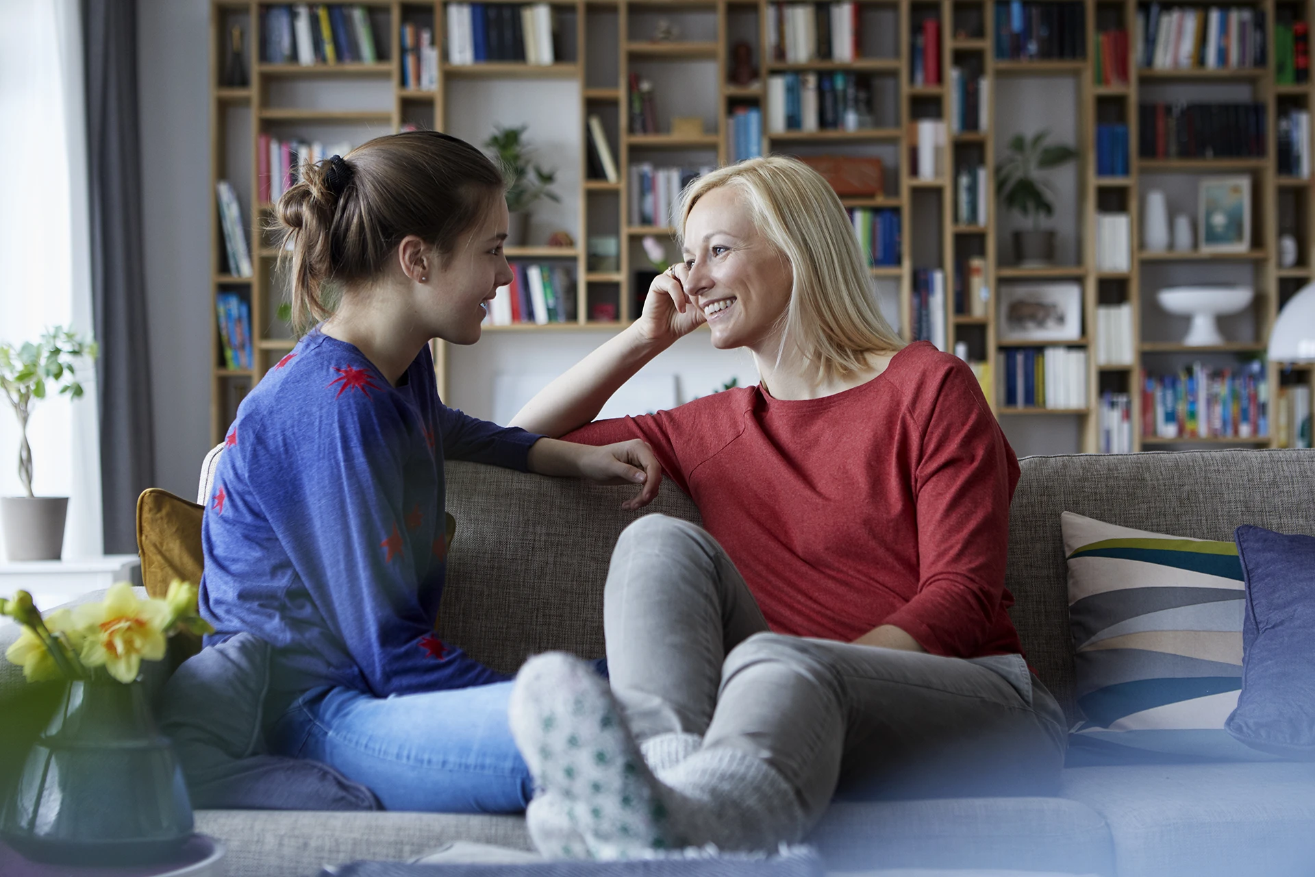 Mother and daughter talking on couch