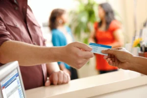 Man handing kaiser membership card to health care provider.